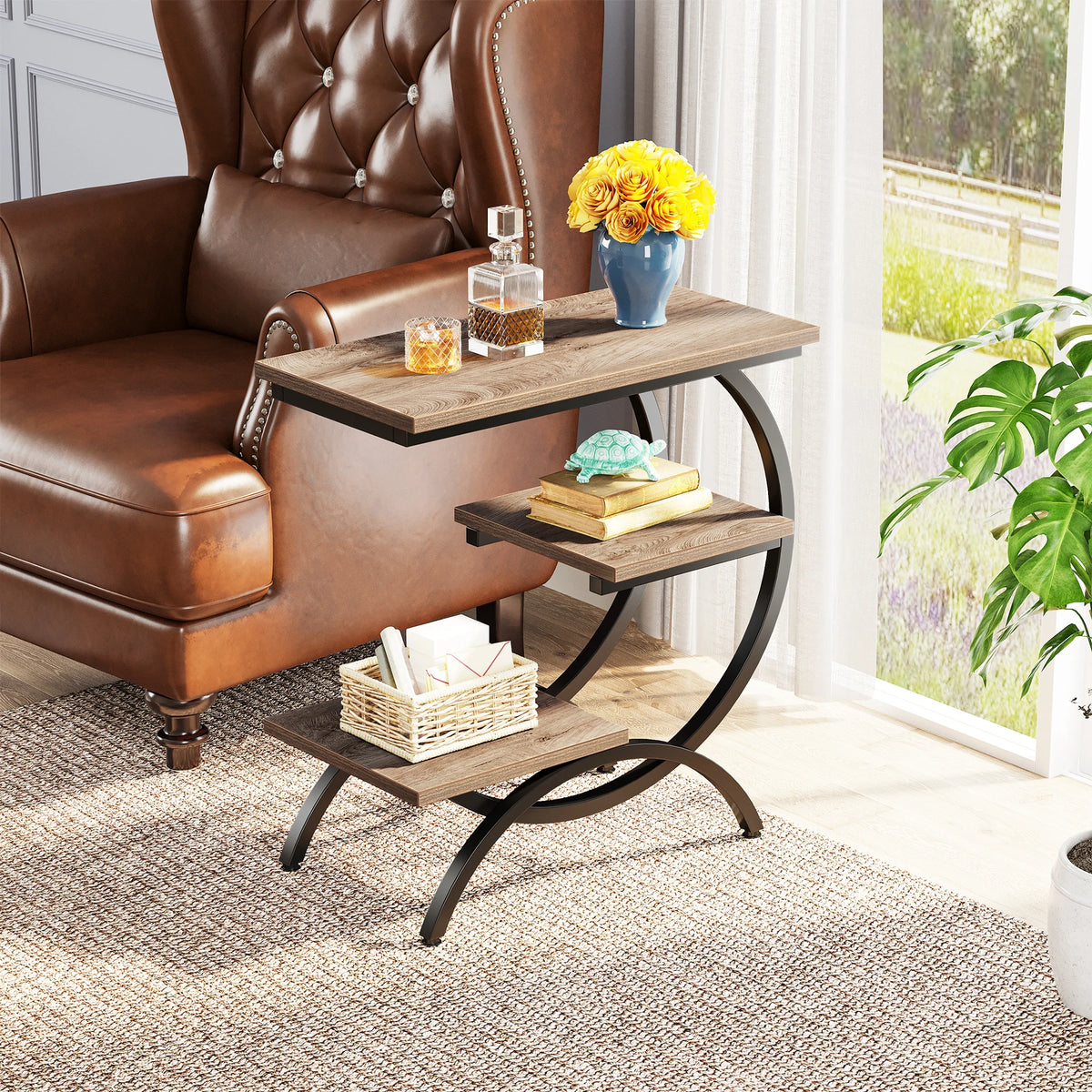 C shaped end table beside a leather armchair with fresh flowers and books displayed on the shelves