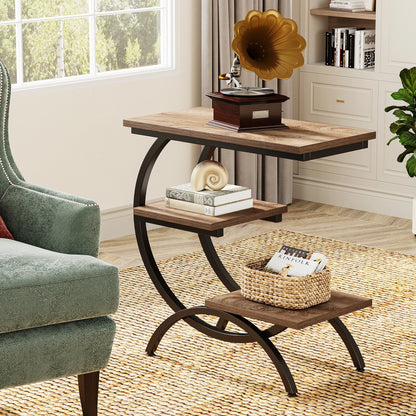 C shaped end table styled with a vintage record player, books and a woven storage basket on the tiered shelves