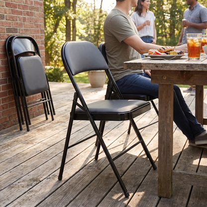 Faux leather padded folding dining chair in black, in use