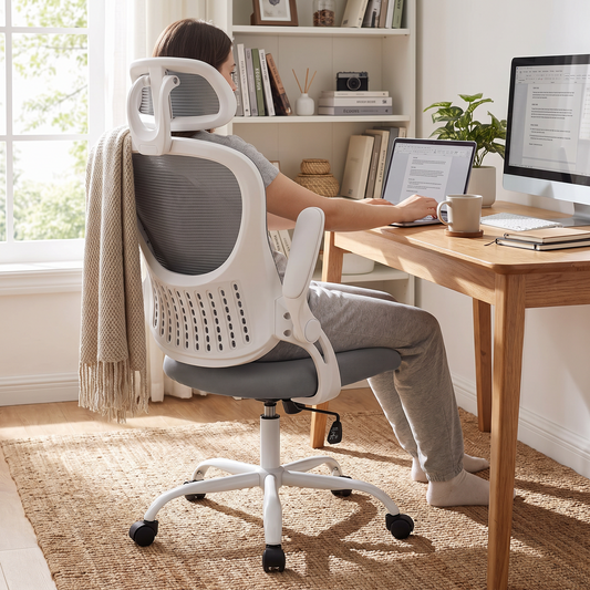 Mesh ergonomic office chair with adjustable headrest in light gray, in use at a desk