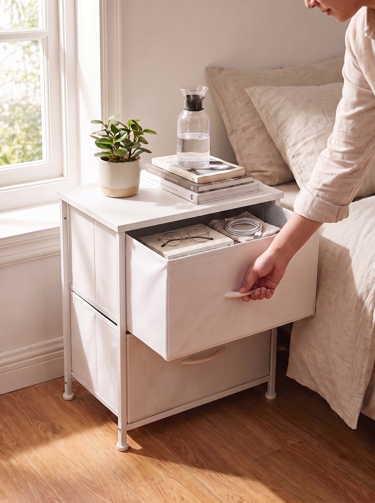 White 2 drawer nightstand with the top fabric drawer pulled open beside a bed