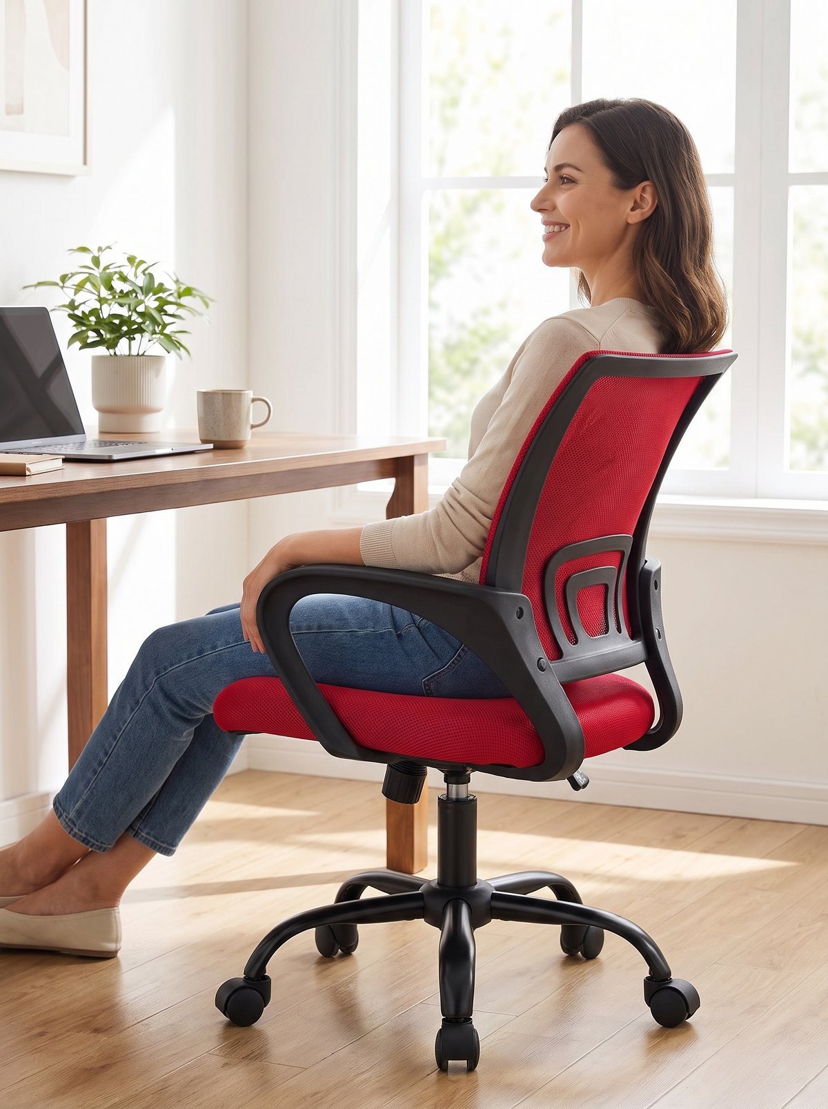 Woman sitting comfortably in the red mesh mid back office chair with her back supported, smiling and relaxed