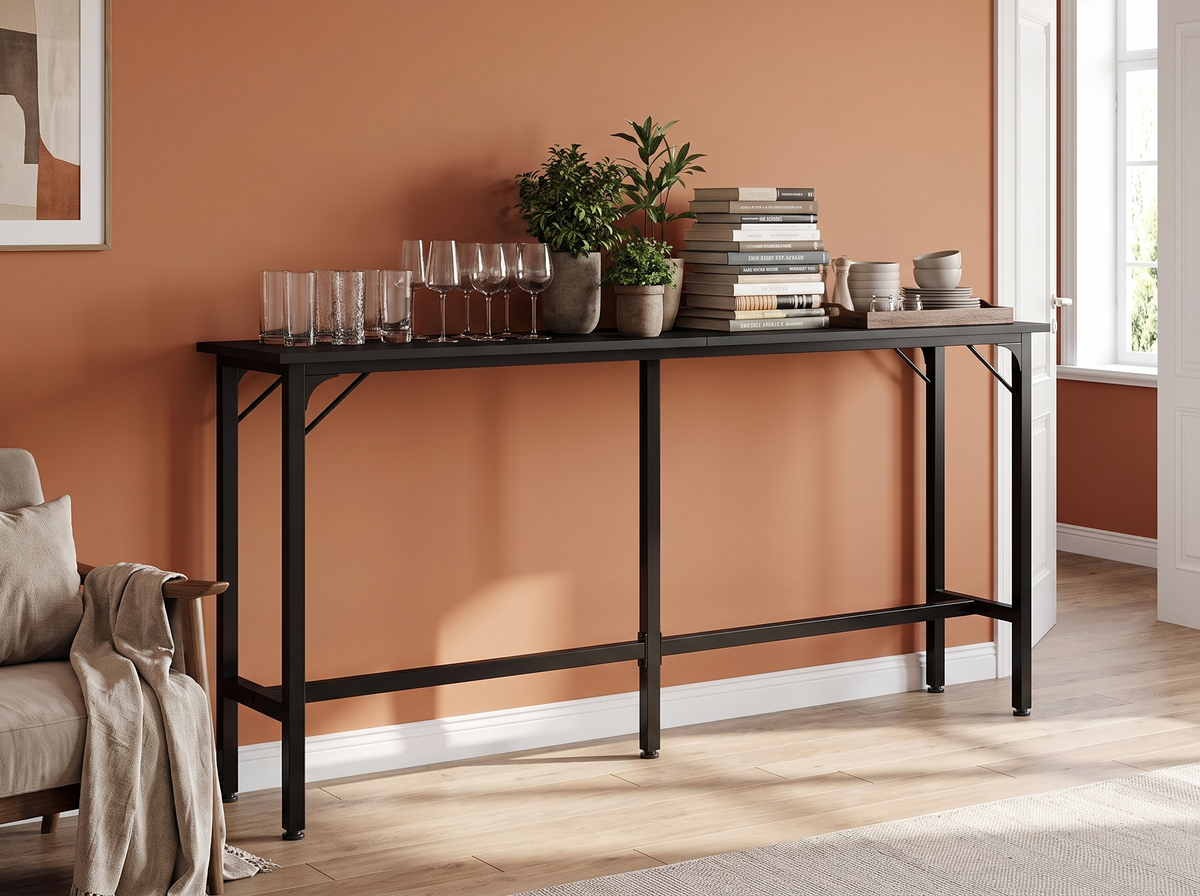 Black console table loaded with glassware, plants, books and dishes against a wall